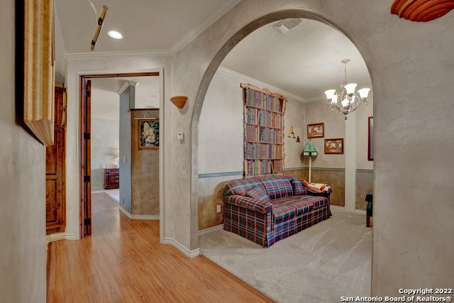 interior space with crown molding, a notable chandelier, and light colored carpet