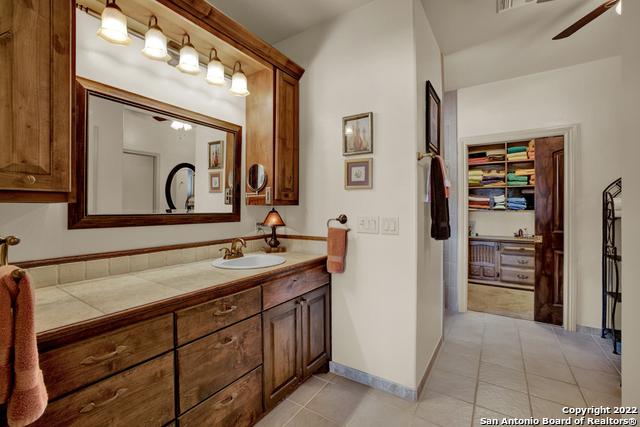 bathroom featuring tile floors, ceiling fan, and vanity