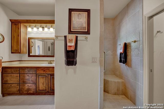 bathroom featuring large vanity, tile floors, and a shower with shower door