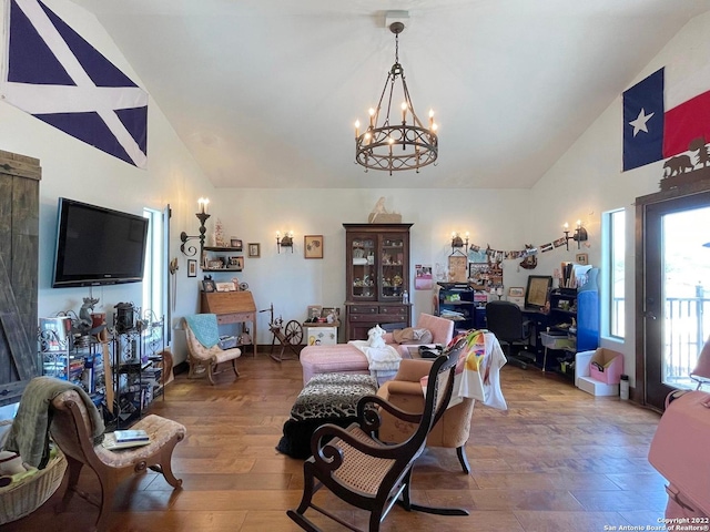 living room featuring hardwood / wood-style floors, a notable chandelier, and vaulted ceiling