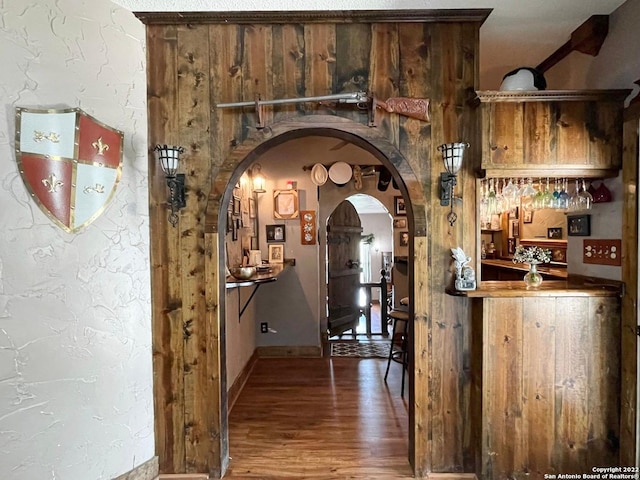 hall featuring dark hardwood / wood-style floors and wooden walls