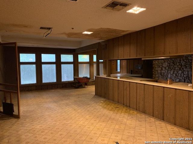 kitchen with wooden walls, light tile floors, and a textured ceiling