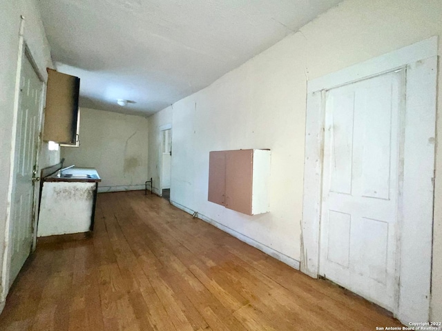 unfurnished living room with sink and light hardwood / wood-style flooring