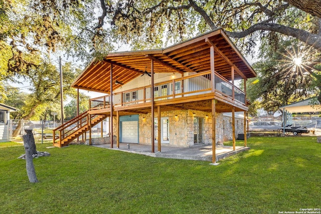 back of property with a yard, a patio area, and a deck