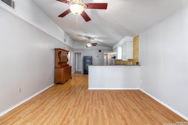 kitchen featuring white cabinets, light hardwood / wood-style flooring, ceiling fan, and kitchen peninsula