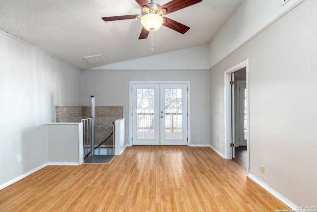 unfurnished living room with french doors, ceiling fan, light hardwood / wood-style flooring, a textured ceiling, and lofted ceiling