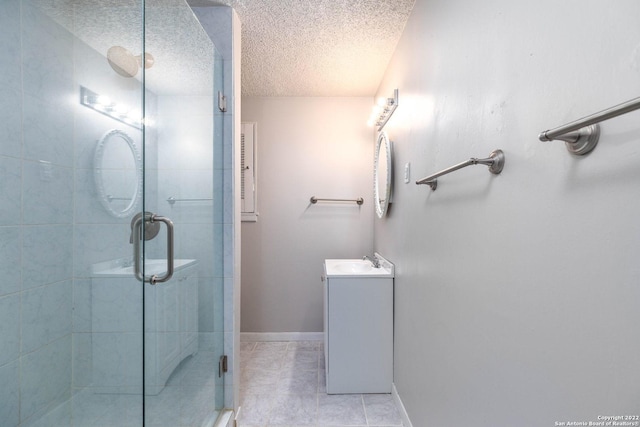 bathroom with a textured ceiling, a shower with door, tile floors, and vanity