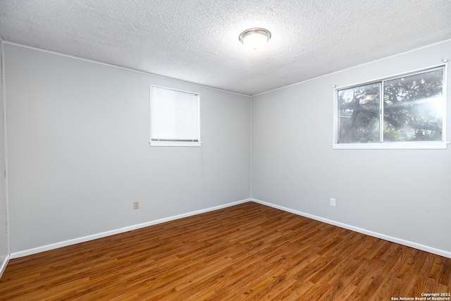 empty room featuring a textured ceiling and wood-type flooring