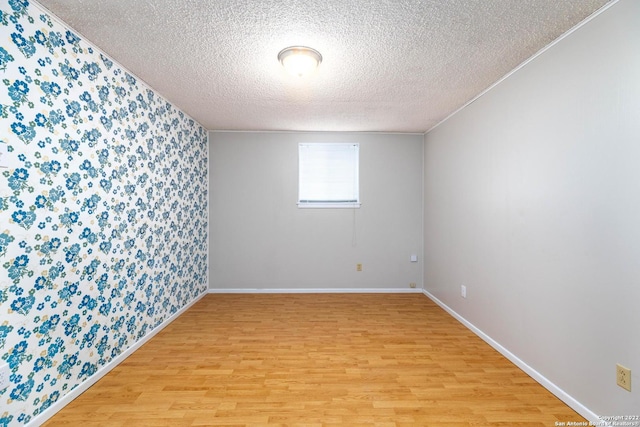 empty room with light hardwood / wood-style floors and a textured ceiling