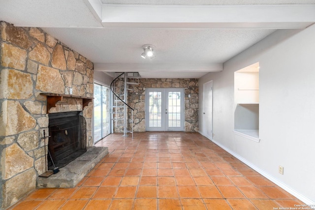 unfurnished living room featuring french doors, a textured ceiling, a fireplace, and light tile floors