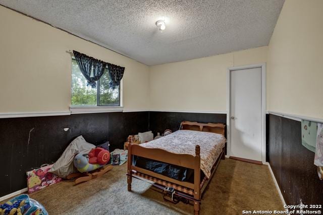 bedroom featuring a textured ceiling and carpet