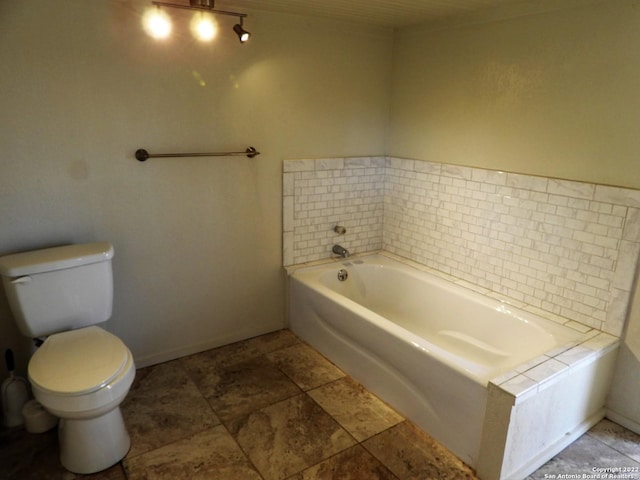 bathroom featuring a washtub, tile floors, and toilet