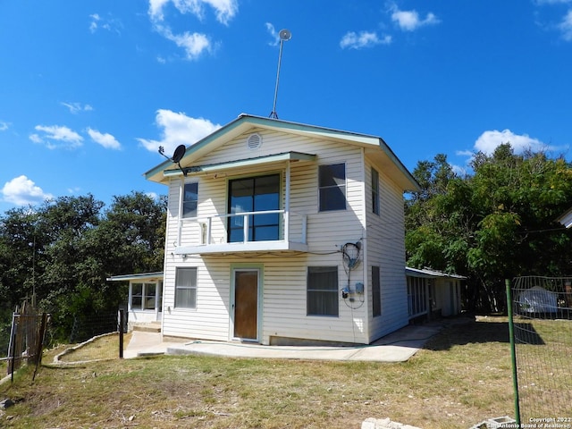 back of property with a lawn and a patio