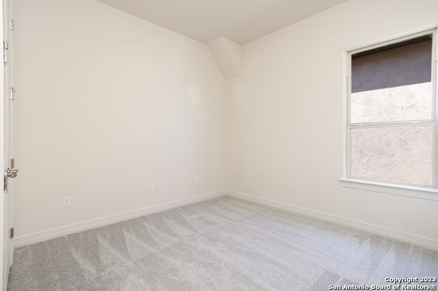 spare room featuring light colored carpet