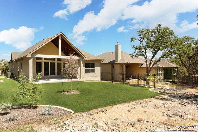 rear view of property featuring a lawn