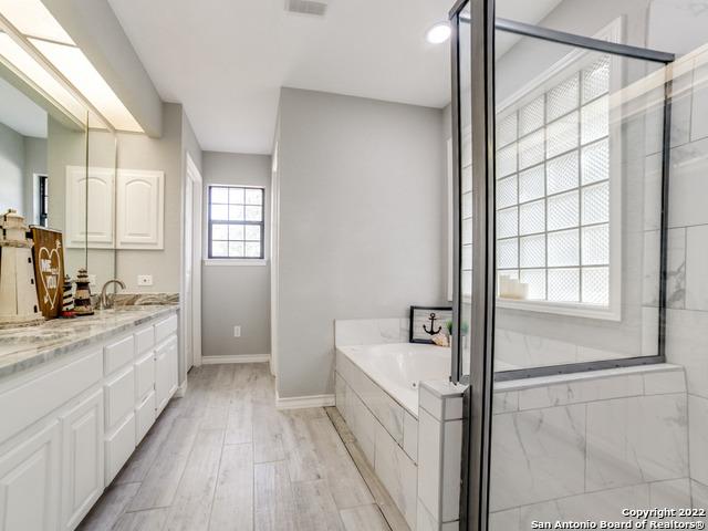 bathroom with hardwood / wood-style floors, vanity, and independent shower and bath