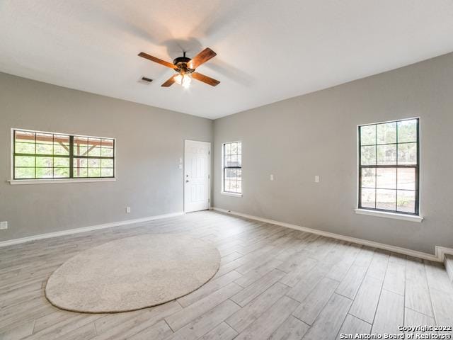 spare room featuring ceiling fan, light hardwood / wood-style flooring, and plenty of natural light