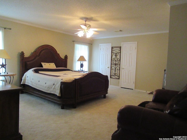 carpeted bedroom with crown molding and ceiling fan