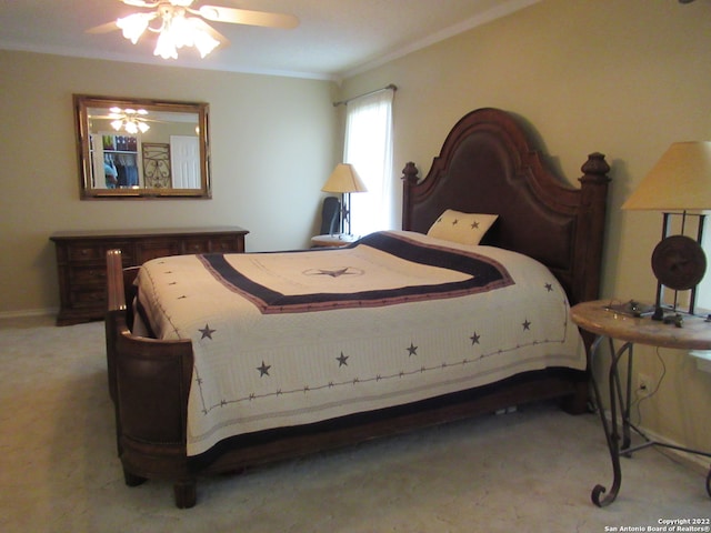 bedroom featuring ornamental molding, light colored carpet, and ceiling fan