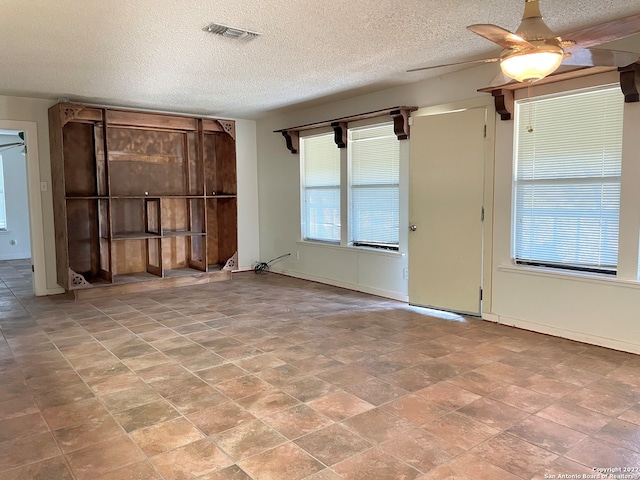 spare room with light tile flooring, ceiling fan, and a textured ceiling