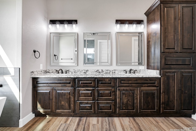 bathroom featuring hardwood / wood-style flooring, vanity, and a bathtub