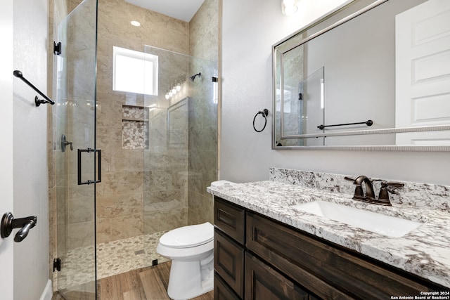 bathroom featuring hardwood / wood-style floors, vanity, an enclosed shower, and toilet