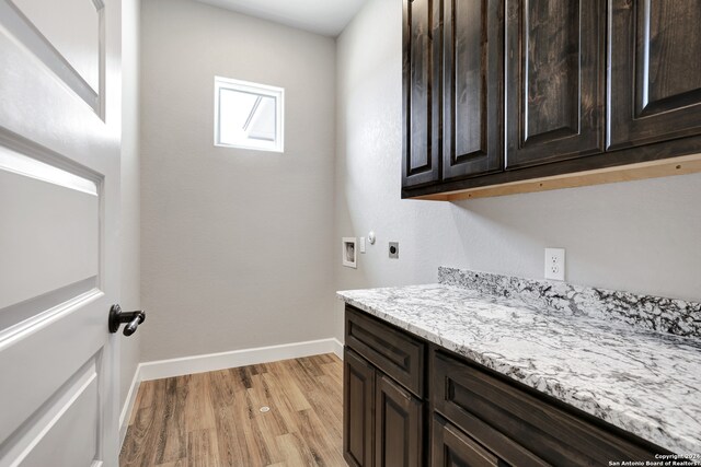 washroom with hookup for an electric dryer, cabinets, light wood-type flooring, and hookup for a washing machine