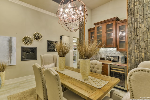 dining room with an inviting chandelier, beverage cooler, and light hardwood / wood-style floors