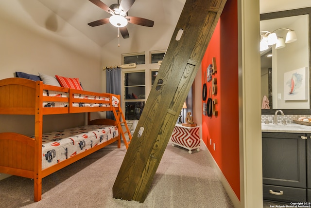 carpeted bedroom featuring vaulted ceiling, ceiling fan, and sink