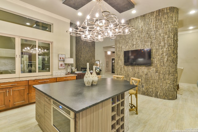 kitchen featuring a chandelier, built in microwave, a kitchen island, a kitchen bar, and pendant lighting