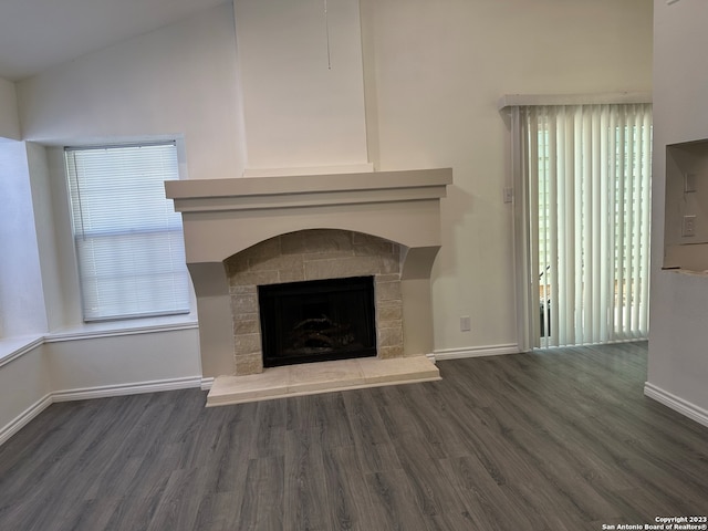 unfurnished living room featuring vaulted ceiling and dark hardwood / wood-style flooring