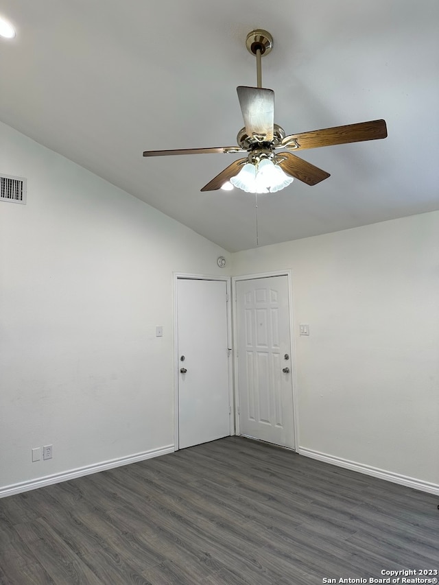 empty room with ceiling fan, lofted ceiling, and dark hardwood / wood-style flooring