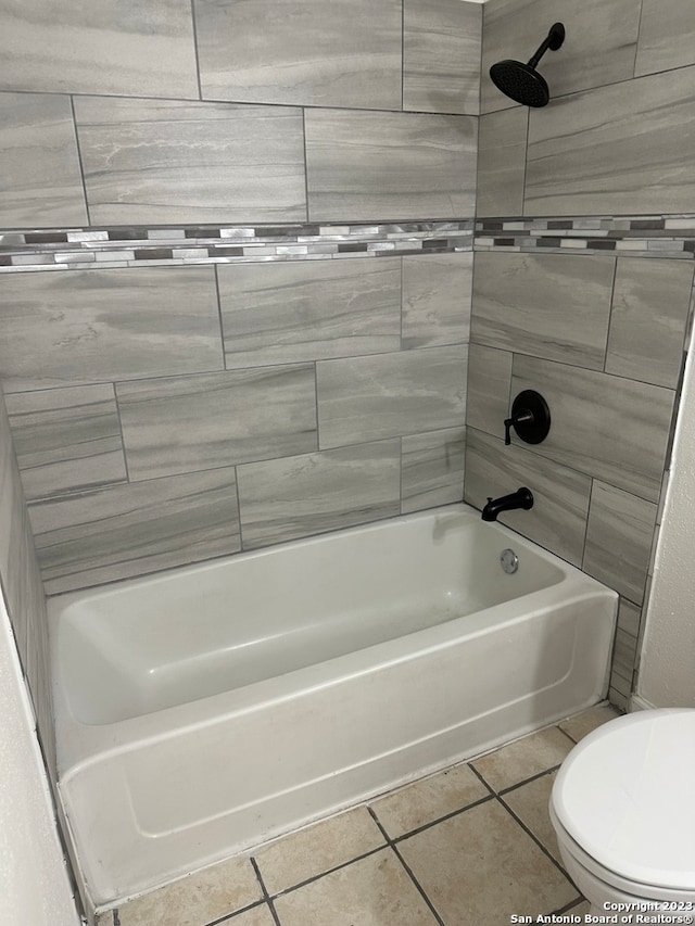 bathroom featuring toilet and tiled shower / bath combo