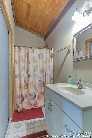 bathroom with crown molding, wood ceiling, tile flooring, large vanity, and lofted ceiling