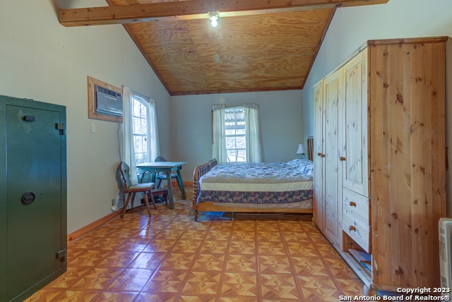 bedroom featuring light parquet flooring, an AC wall unit, and lofted ceiling with beams