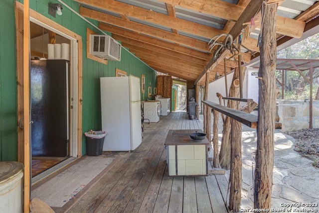 wooden deck with an AC wall unit and washer / clothes dryer