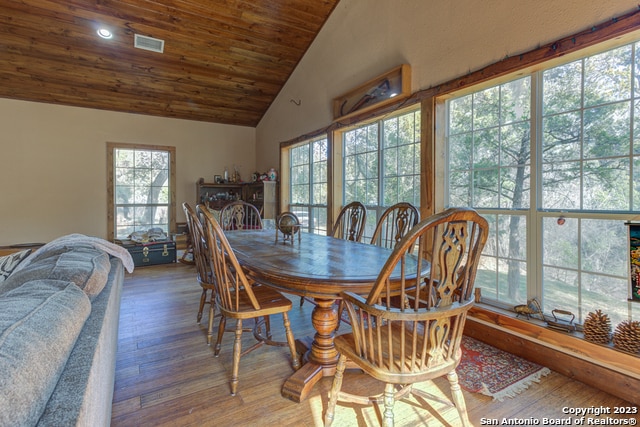 dining area with plenty of natural light, wooden ceiling, high vaulted ceiling, and dark hardwood / wood-style floors