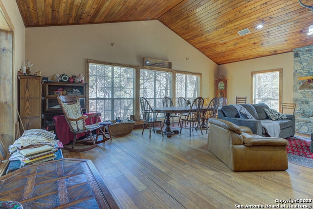 living room featuring light hardwood / wood-style floors, wooden ceiling, and high vaulted ceiling