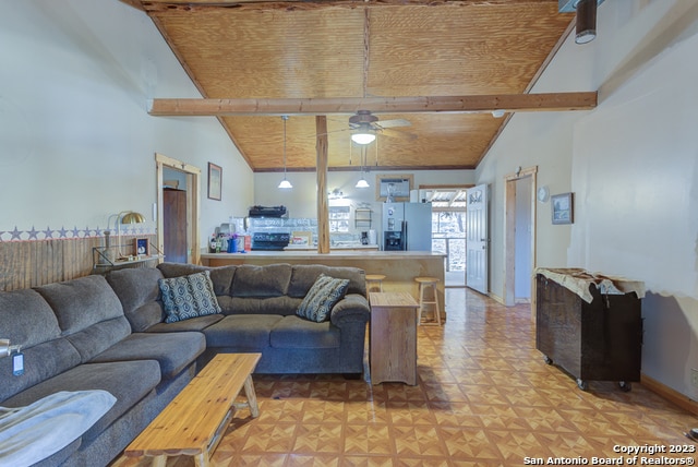 living room featuring ceiling fan, light parquet flooring, and vaulted ceiling with beams