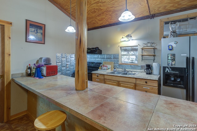 kitchen featuring wooden ceiling, stainless steel refrigerator with ice dispenser, pendant lighting, and sink