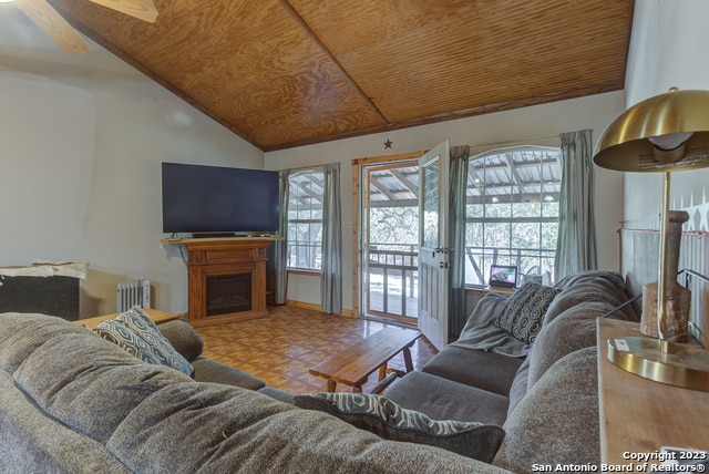 living room featuring radiator heating unit, wooden ceiling, vaulted ceiling, and ceiling fan