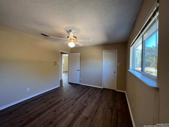119 Cedar Tree Ln, Canyon Lake, TX 78133 - spare room featuring ceiling fan, a textured ceiling, and dark wood-type flooring