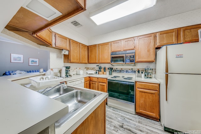 kitchen featuring tasteful backsplash, white appliances, and light hardwood / wood-style flooring