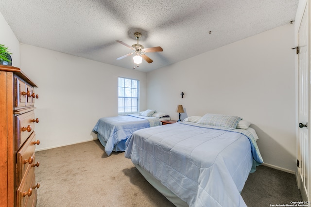 bedroom featuring ceiling fan, light carpet, and a textured ceiling