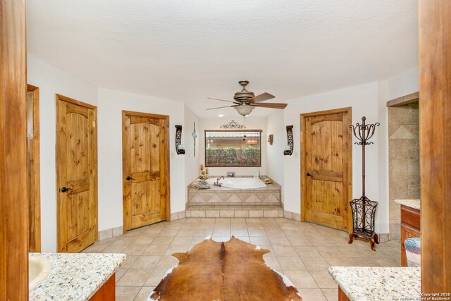 interior space featuring light tile floors, ceiling fan, and a textured ceiling