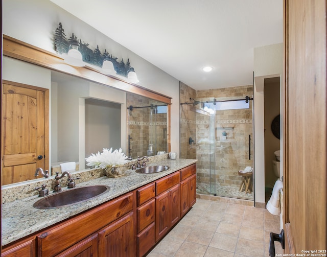 bathroom with toilet, a shower with door, tile floors, dual sinks, and large vanity