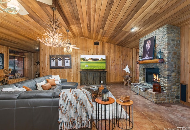 living room with tile flooring, a chandelier, wooden ceiling, wooden walls, and a stone fireplace