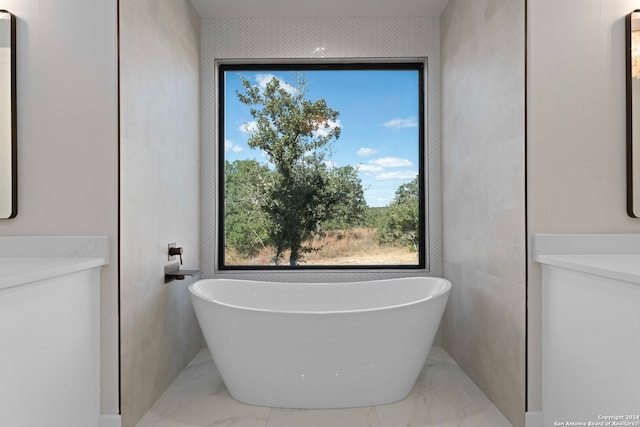 bathroom with a washtub, vanity, and tile walls