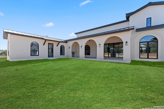 rear view of house featuring a yard