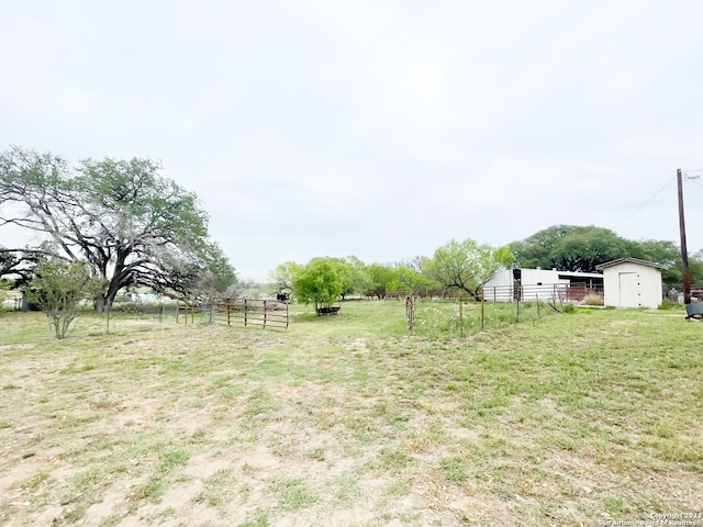 view of yard featuring a rural view and a shed